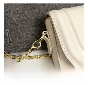 Détail d'un crochet en métal doré de haute qualité sur un sac en cuir matelassé blanc