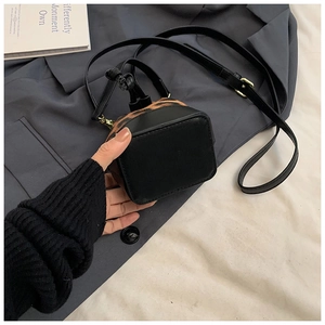Detail of leopard print bucket bag with drawstring closure and golden metal buckles