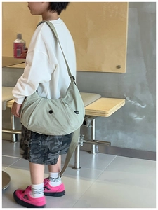 Detail einer hellgrünen Nylon-Halbmond-Umhängetasche für Kinder mit verstellbarem Gurt