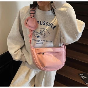 Vue détaillée du sac bandoulière rose en toile avec une petite pochette ronde