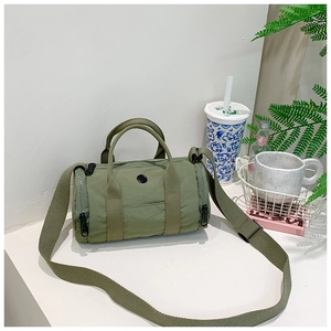 Close-up of olive green cylindrical kid bag with wide strap and dual top handles