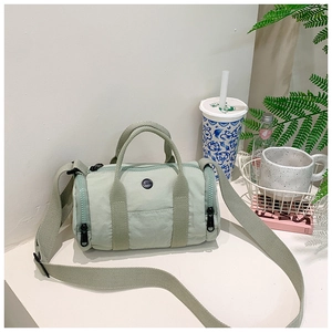 Detail view of mint green barrel bag with adjustable strap and dual handles