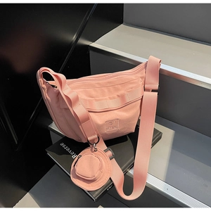 Vue détaillée du sac en nylon rose en forme de croissant avec son petit porte-monnaie rond