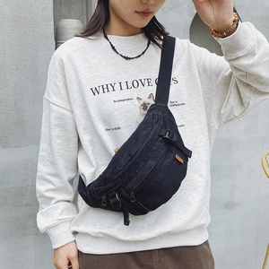 Sac de poitrine en denim noir pour femme avec bandoulière réglable porté par un mannequin