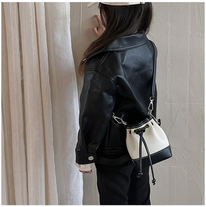 Detailed back view of a child modeling the black and white contrast bucket bag