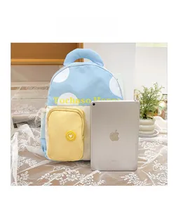 Größenvergleich des blau-weißen gepunkteten Kinderrucksacks neben einem Tablet