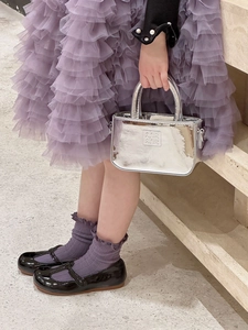 Dettaglio della mini borsa a mano argento specchiato per bambine con logo a sbalzo