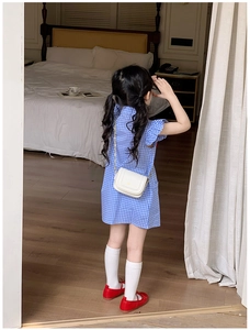 Détail d'une robe d'été pour fille à carreaux vichy bleus avec manches à volants