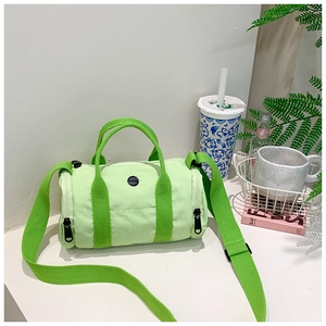 Detail of light green nylon cylinder bag with bright green straps and black circular logo