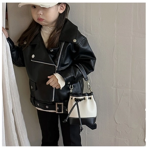 Close-up of children's mini bucket bag with textured pattern and metal lock details