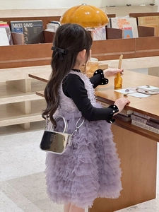 Dettaglio della mini borsa argento specchio laser con catena in metallo su abito viola