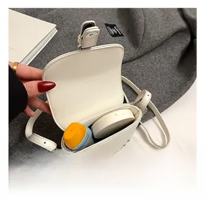 Interior view showing capacity of white mini saddle bag with silver studs and strap