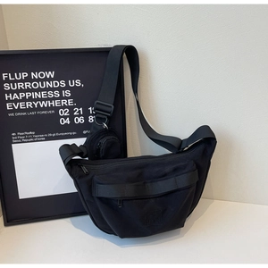 Détail d'un sac bandoulière croissant en nylon noir avec sangle large et petit porte-monnaie