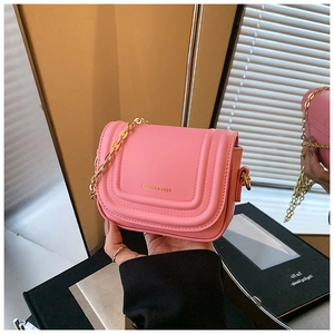Détail du mini sac à bandoulière en cuir rose avec chaîne dorée et coutures incurvées