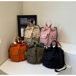 Detail view of five nylon bucket bags in beige pink orange green and black colors