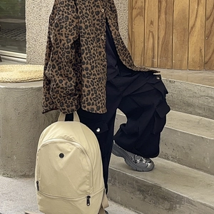 Minimalist beige backpack for kids paired with leopard shirt and cargo pants outfit