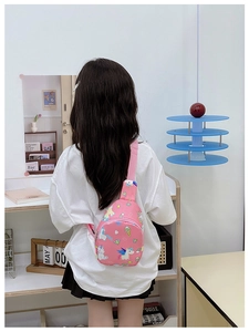 Rear view of a pink cartoon unicorn chest bag worn by a child in a lifestyle setting