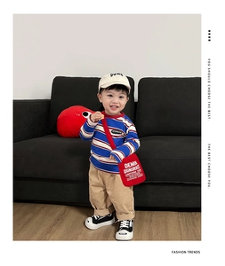 Dettaglio borsa a tracolla per bambini in tela con stampa e t-shirt a righe