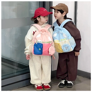 Detailansicht von Kinder-Rucksäcken in Rosa und Blau, getragen von jungen Models