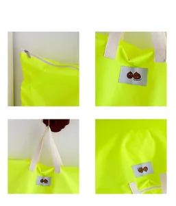 Close-up of neon yellow travel tote showing zipper detail and cartoon patch design