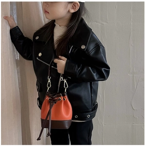 Detail of kids mini bucket bag with orange pebble leather and golden metal hardware