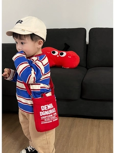 Dettaglio borsa a tracolla rossa per bambini in tela con stampa di lettere e tracolla regolabile