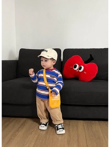 Dettaglio di un completo bimbo con t-shirt a righe e borsa a tracolla gialla vivace