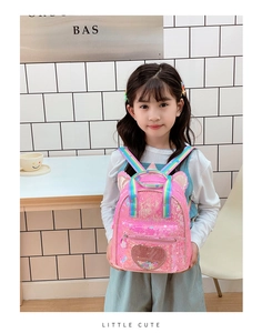 Pink sequin kids backpack with heart glitter pocket and cute ears on indoor model
