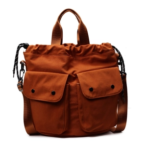 Caramel canvas drawstring bucket bag with multiple pockets and adjustable strap