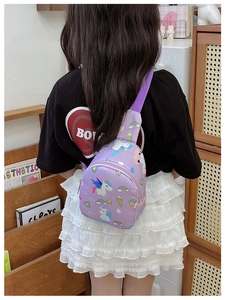 Rear view of a child wearing the purple unicorn pattern crossbody chest bag in a home setting