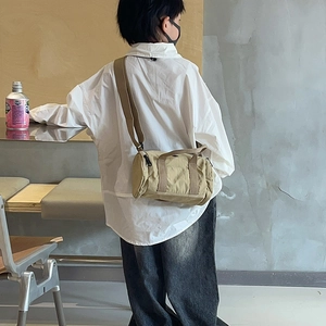 Minimalist tan nylon cylinder crossbody bag with top handles and adjustable strap for kids