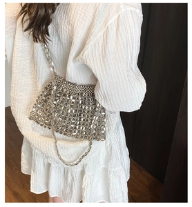 Detail of silver chainmail shoulder bag showing intricate metallic disc weaving and texture