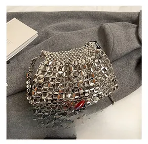 Detailed close-up of silver sequin metal link handbag featuring futuristic woven mesh texture