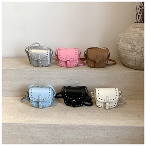 Detailed group view of mini rivet saddle bags in six colors displayed on stone steps