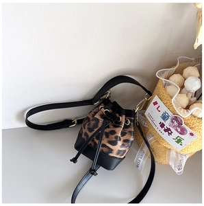 Detail of mini leopard print bucket bag with black drawstring and gold metal hooks