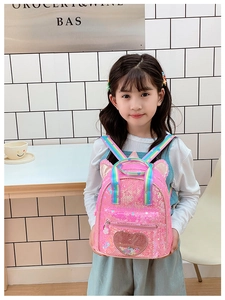 Close-up of pink sequin kids backpack featuring unicorn ears and rainbow straps