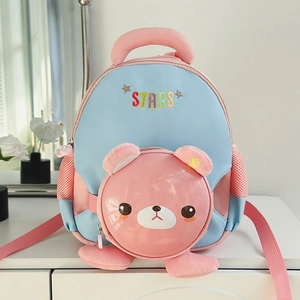 Détail de la poche ours rose et de la broderie STARS sur le sac à dos bleu enfant