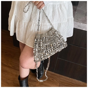 Detail showing hand-woven silver metal sequins and chain strap of this chic shoulder bag
