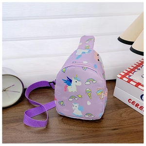 Close-up of a purple cartoon unicorn chest bag for kids on a wooden desk with a warm lamp