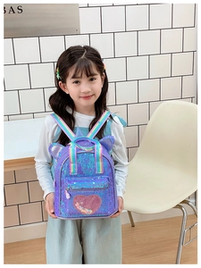 Close-up of kids purple sequin backpack with cat ears and rainbow straps in a studio