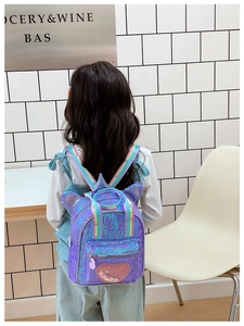 Detail of purple sequin kids backpack with cat ears and rainbow straps shown on model
