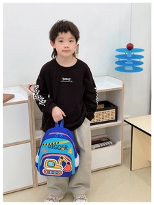 Sac à dos bleu pour enfant avec dessin de pelleteuse et poches filet porté par un enfant
