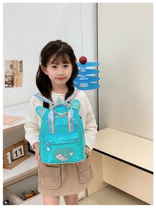Close-up of children's blue sequin backpack featuring rainbow straps and cute animal ears