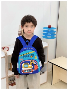 Sac à dos bleu pour enfant avec pelleteuse jaune et filet latéral porté par un enfant