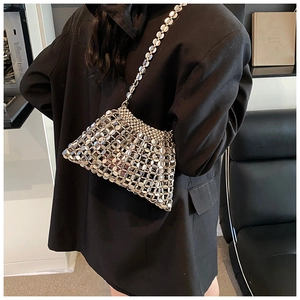 Detail view of a silver metallic chainmail shoulder bag with glossy sequin link structure