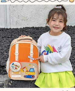 Detail of cute orange digger backpack with excavator embroidery and detachable coin purse