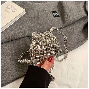Detailed shot of silver metallic disc handbag with chain strap on wool coat background