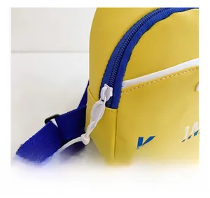 Detailed close-up of smooth blue zipper and Kayi logo on yellow sporty crossbody bag