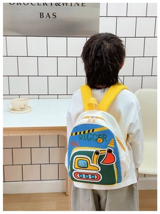Vue détaillée du sac à dos enfant pelleteuse avec des motifs 3D colorés et une poche en filet