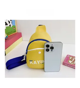Mini yellow chest bag with blue strap compared to a smartphone for size reference